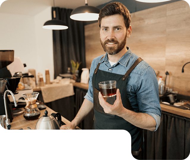 Barista holding a glass of coffee in a café